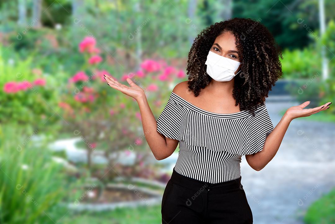 Retrato ao ar livre de uma jovem negra com proteção médica