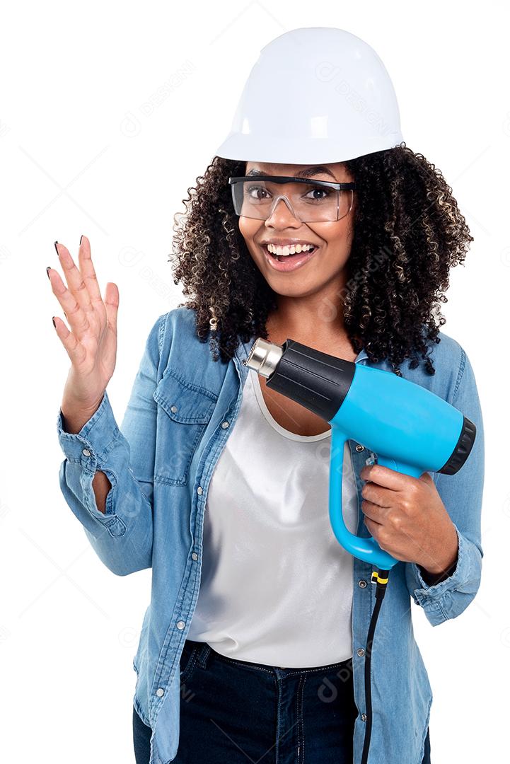 Cheerful and smiling black Brazilian woman isolated on white background working with a heat gun wearing glasses and a helmet on her head.