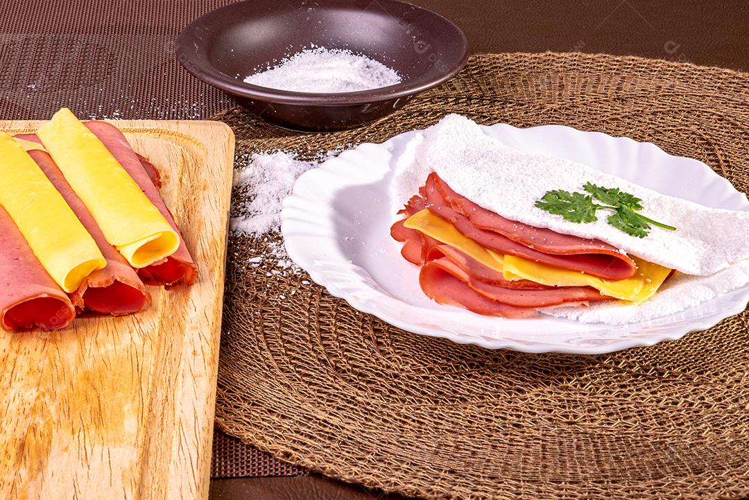 Tapioca beiju com presunto, queijo e mortadela em um prato