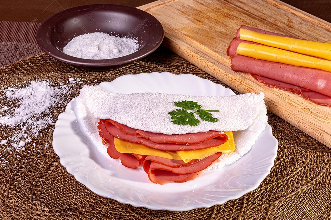 Tapioca beiju com presunto, queijo e mortadela em um prato