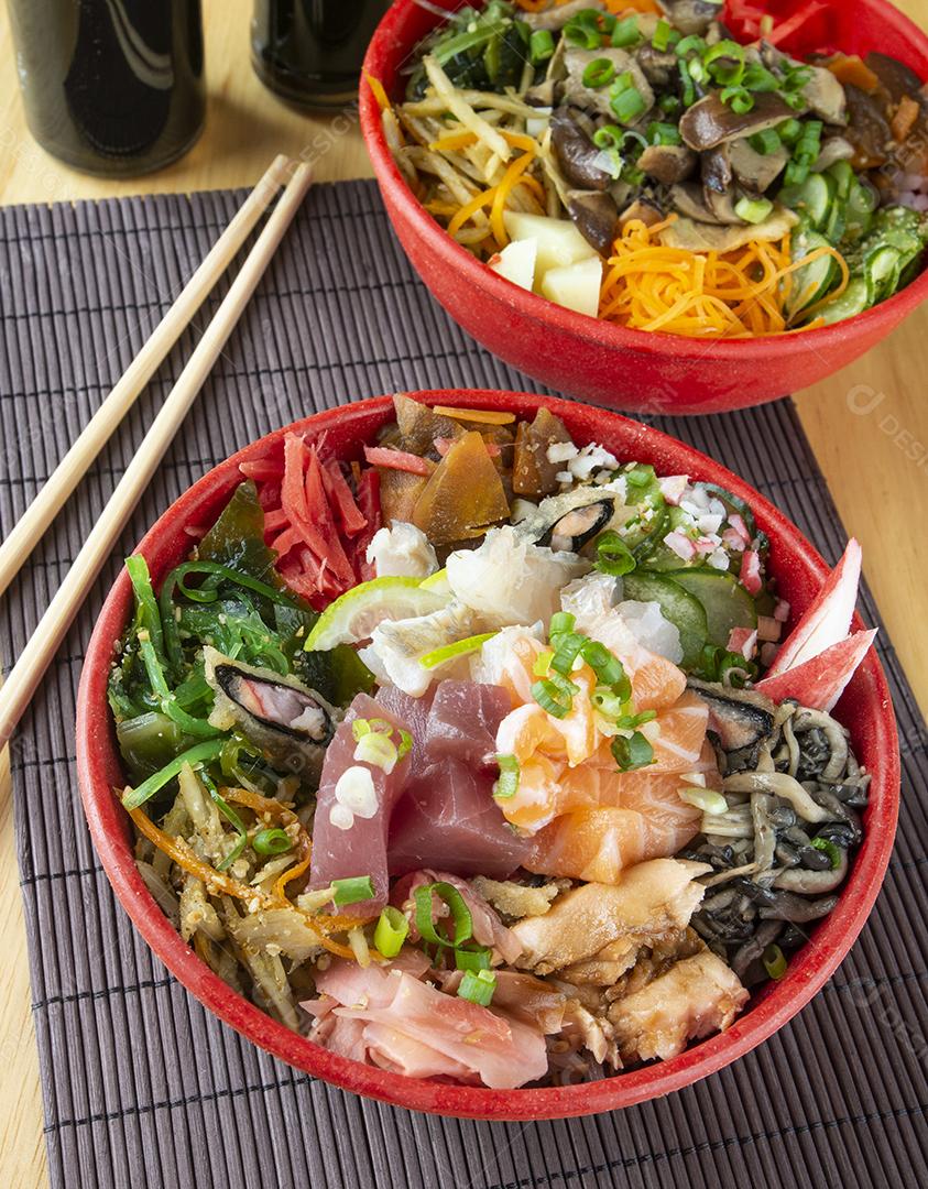 Chirashi de peixe, comida japonesa em tigelas com hashis de madeira
