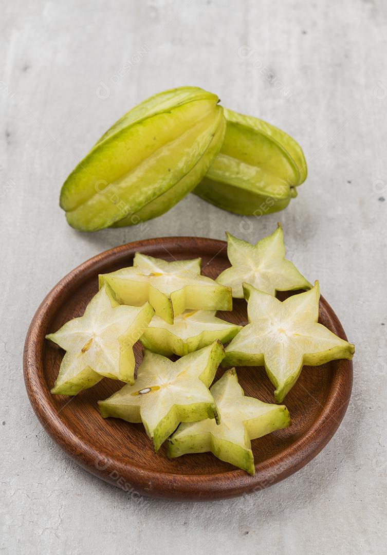 Frutas estelares com fatias sobre um prato de madeira