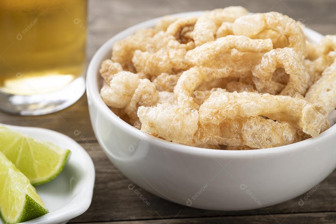 Torres de porco fritos em uma tigela branca com limão e cerveja