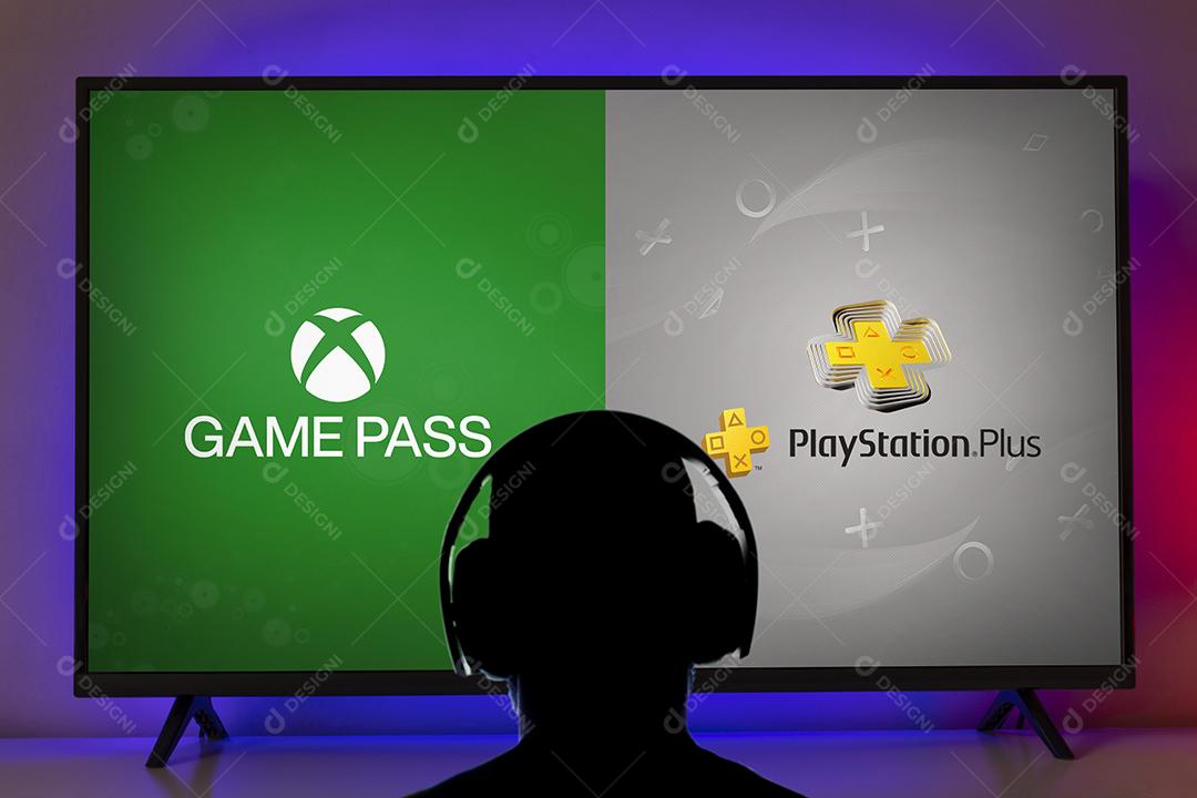 Homem com headfone procurando logotipos game pass e Playstation Plus na tela da TV, 1 abr, 2022, São Paulo, Brasil.