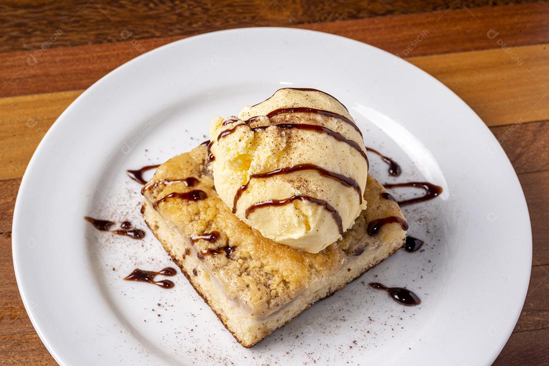 Sorvete com bolo de banana em um prato branco em uma mesa de madeira. Deliciosa sobremesa.
