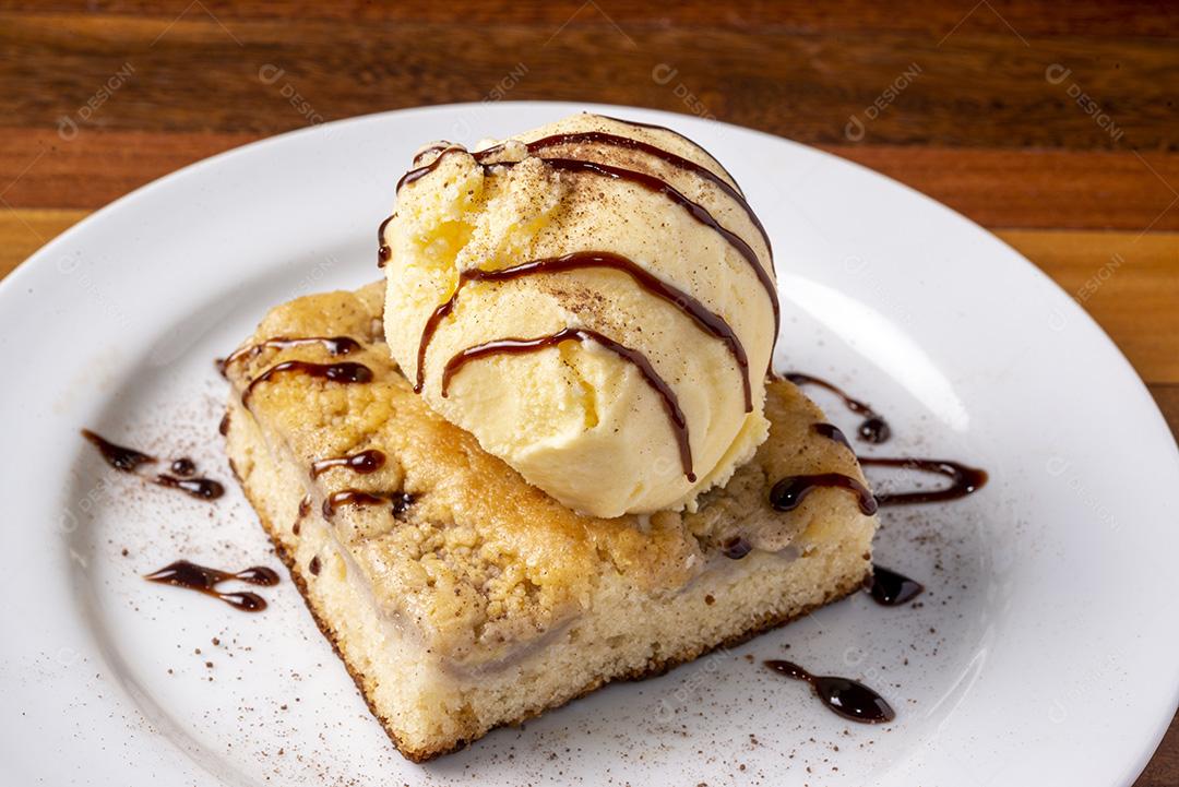 Ice cream with banana cake in a white plate on a wooden table. Delicious dessert.