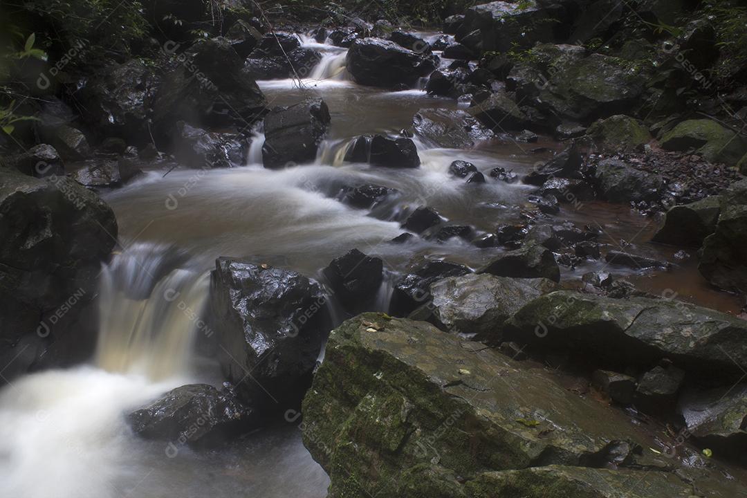 Pequenas cachoeiras em um rio em uma floresta tropical escura em Brotas, Brasil