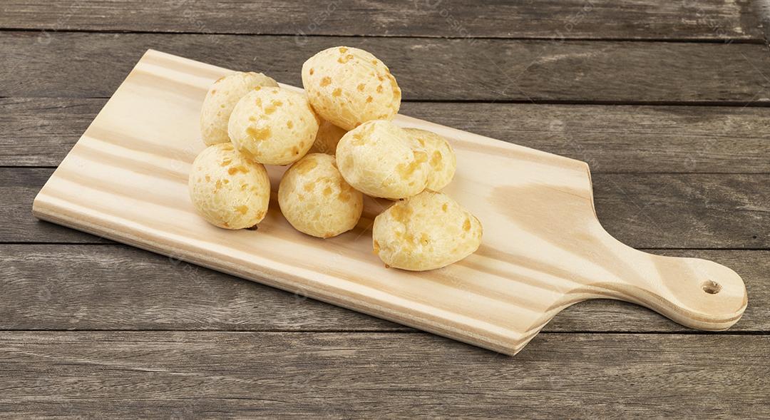 Pão de queijo típico brasileiro sobre uma tábua de madeira.