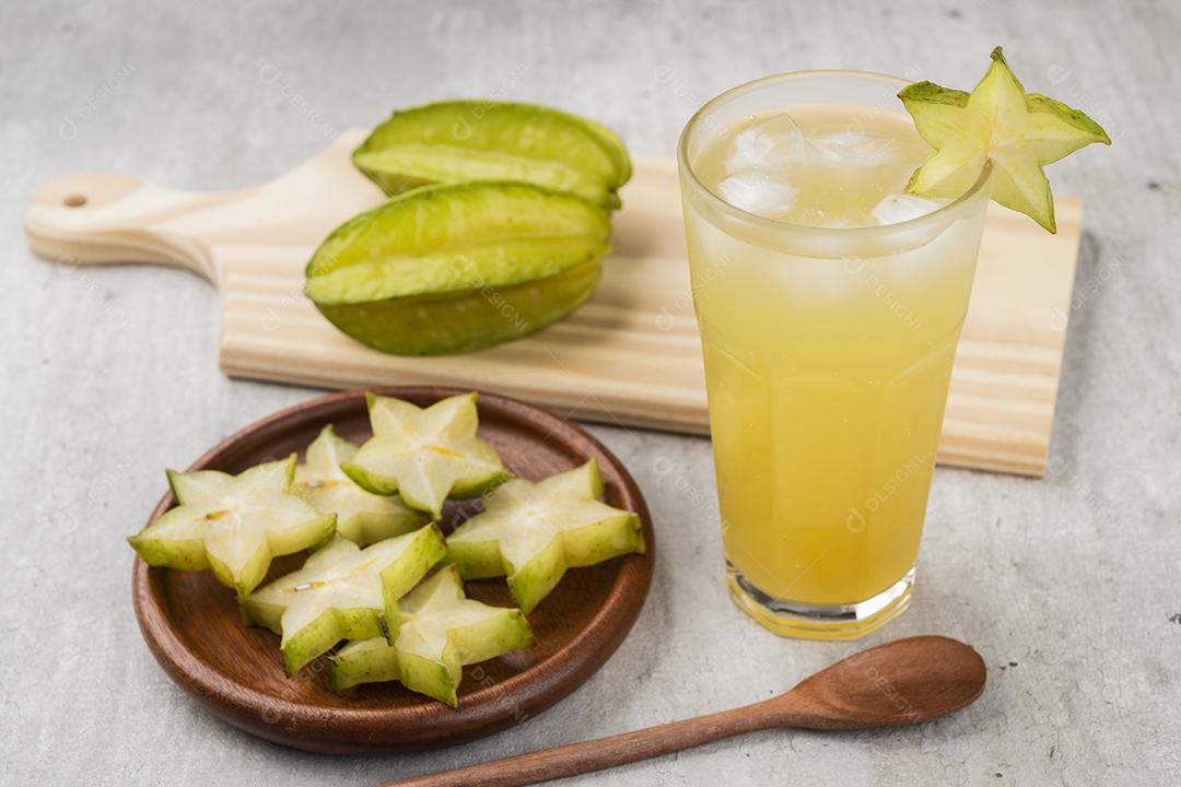 Copo de suco de fruta estrela com fatias de gelo e frutas