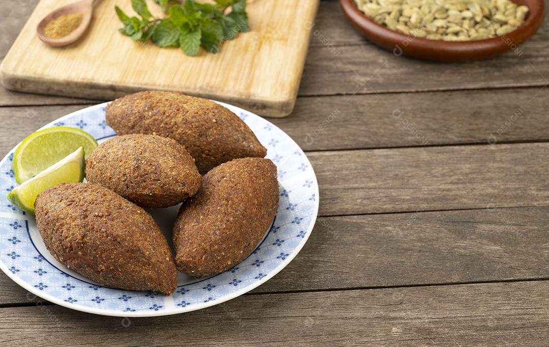 Kibbeh frito árabe tradicional sobre mesa de madeira