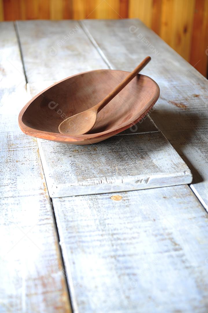 Tigela de madeira colher sobre uma mesa de madeira
