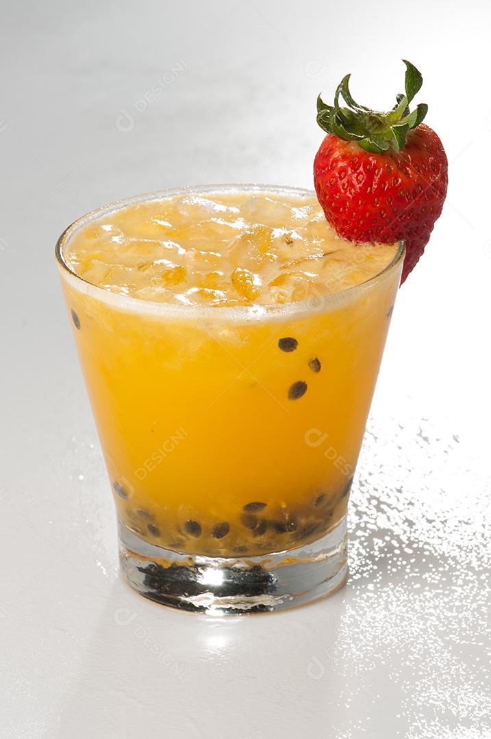Suco de Maracujá com gelo e fruta morango sobre fundo branco