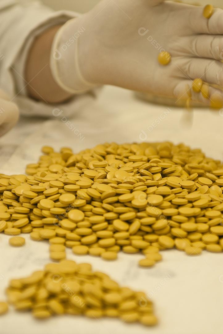 Mão segurando medicamentos, remédios, sobre fundo branco. Clínica