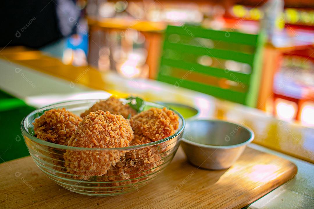 Salgadinho com molho de pimenta, molho verde temperado.