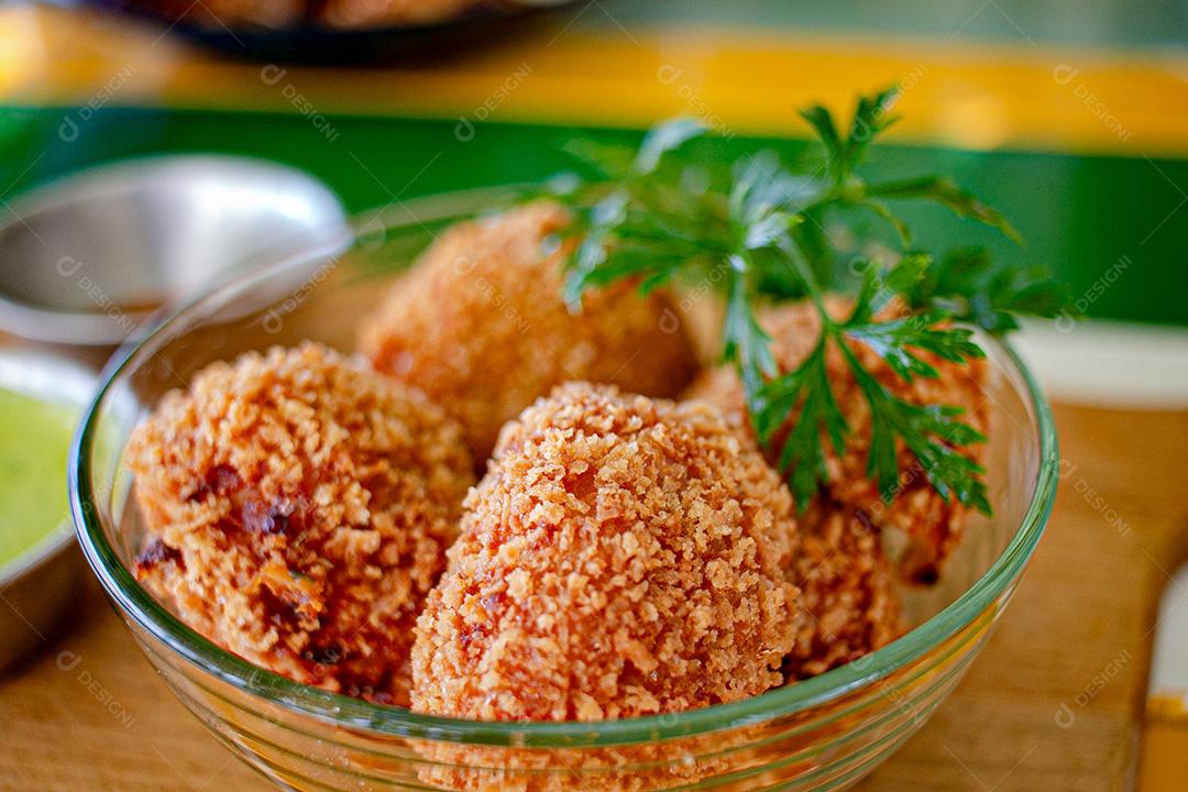 Salgadinho com molho de pimenta, molho verde temperado.