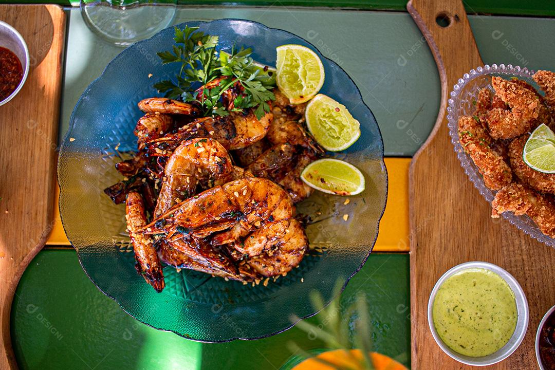 Camarão seco  sobre prato com limões e coentro.