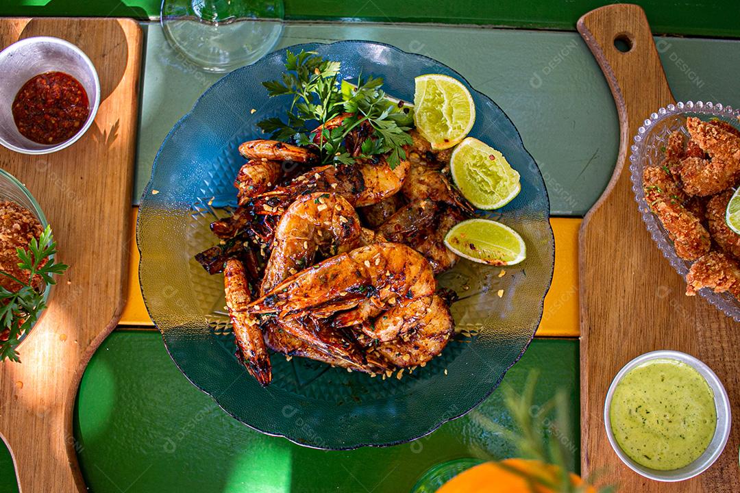 Camarão seco  sobre prato com limões e coentro.