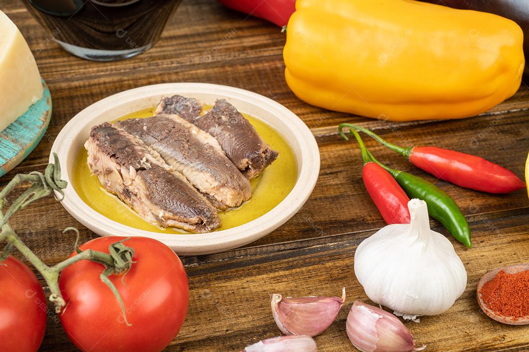 Legumes, azeite, pão, queijo, peixe e vinho e legumes sobre mesa de madeira.  alimento.