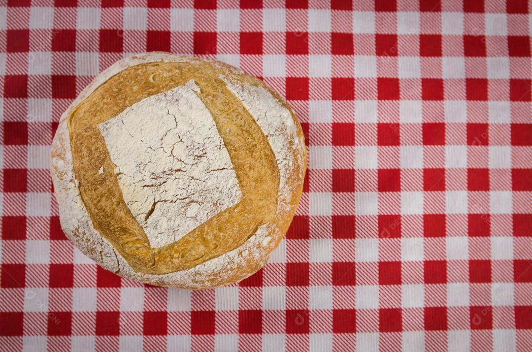 Beautiful sourdough bread being held by woman's hands and blurred background.