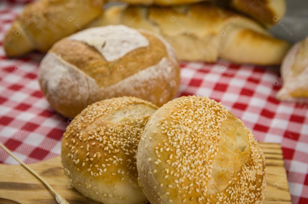 Pão de fermento bonito sendo realizado pelas mãos da mulher e fundo desfocado.