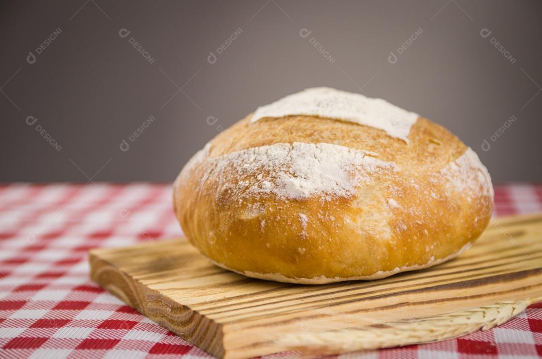 Pão de fermento bonito sendo realizado pelas mãos da mulher e fundo desfocado.