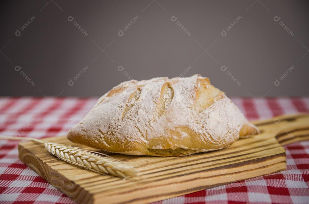 Pão de fermento bonito sendo realizado pelas mãos da mulher e fundo desfocado.