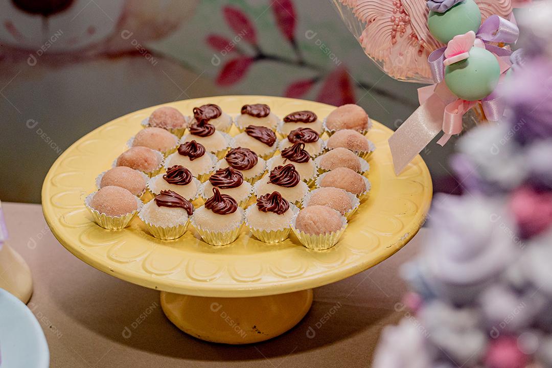 Bolinhos, doces confeitados para festa, eventos, sobre suporte de madeira.