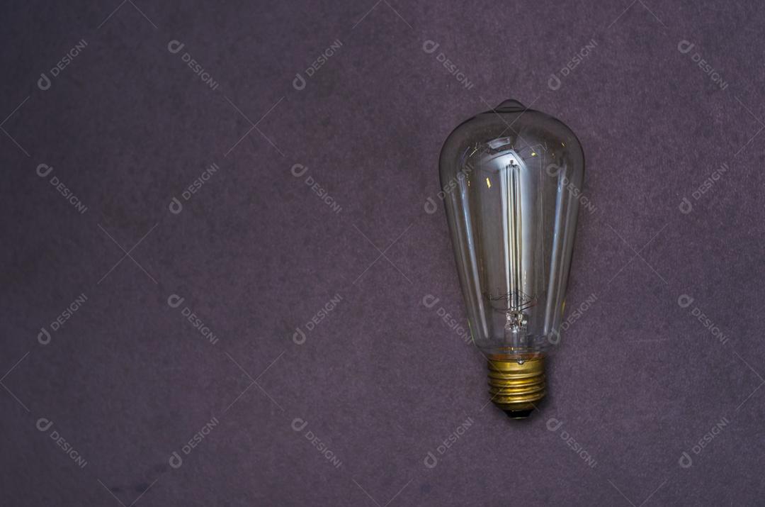 Grande conceito de ideia e criatividade, lâmpada acesa, sem fio, em fundo roxo.