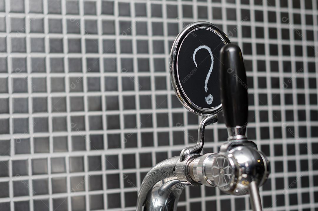 Torneira de cerveja com medalhão com ponto de interrogação como descrição.