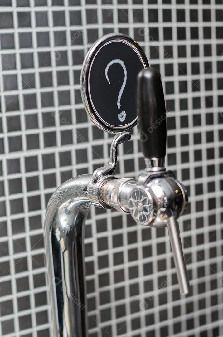Torneira de cerveja com medalhão com ponto de interrogação como descrição.