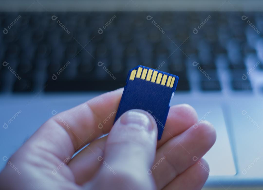 Cartão de memória SD em cima do computador. Plano de fundo para o tema tecnológico.
