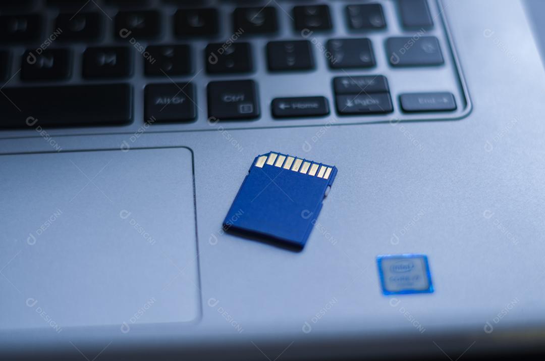 Cartão de memória SD em cima do computador. Plano de fundo para o tema tecnológico.