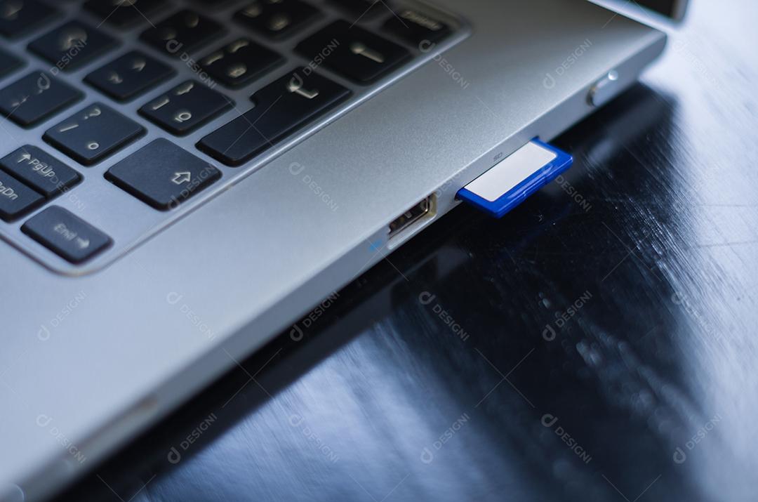 Cartão de memória SD em cima do computador. Plano de fundo para o tema tecnológico.