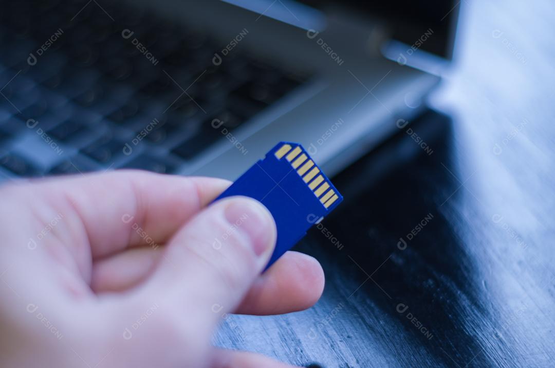 Cartão de memória SD em cima do computador. Plano de fundo para o tema tecnológico.