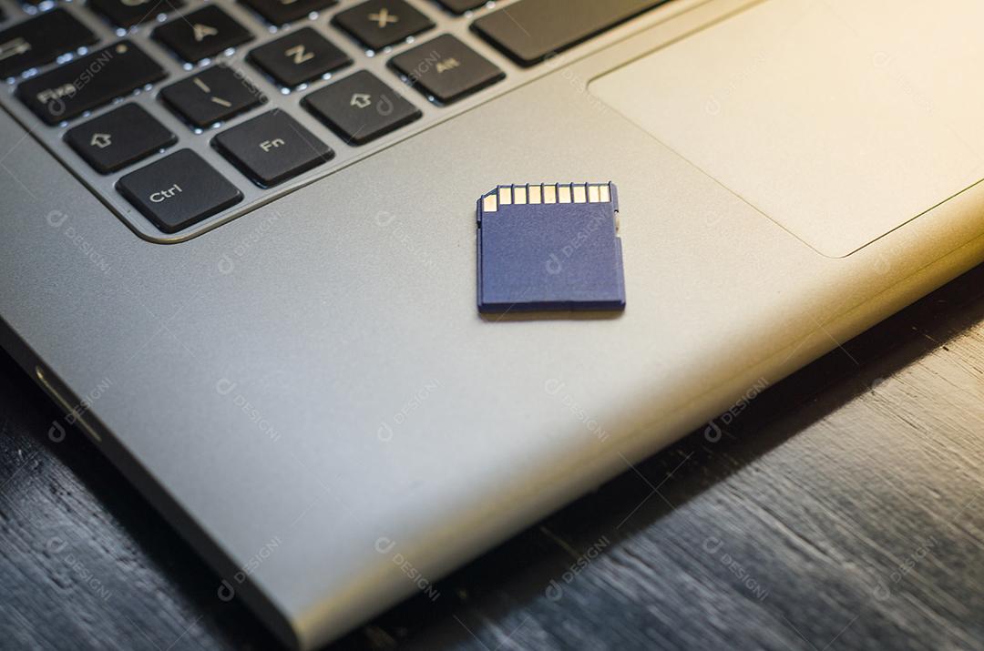 Cartão de memória SD em cima do computador. Plano de fundo para o tema tecnológico.
