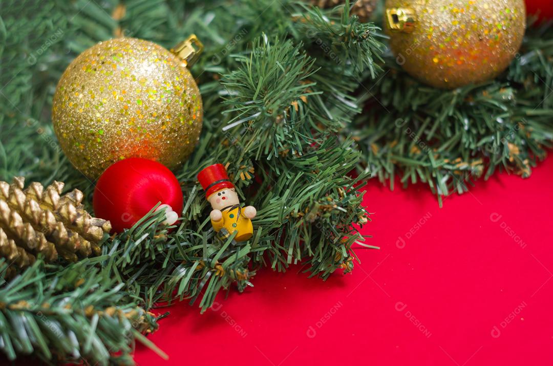 Textura com tema de Natal com folhas verdes, objetos decorativos e fundo vermelho