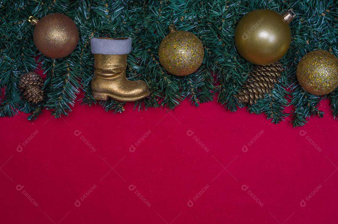 Textura com tema de Natal com folhas verdes, objetos decorativos e fundo vermelho.