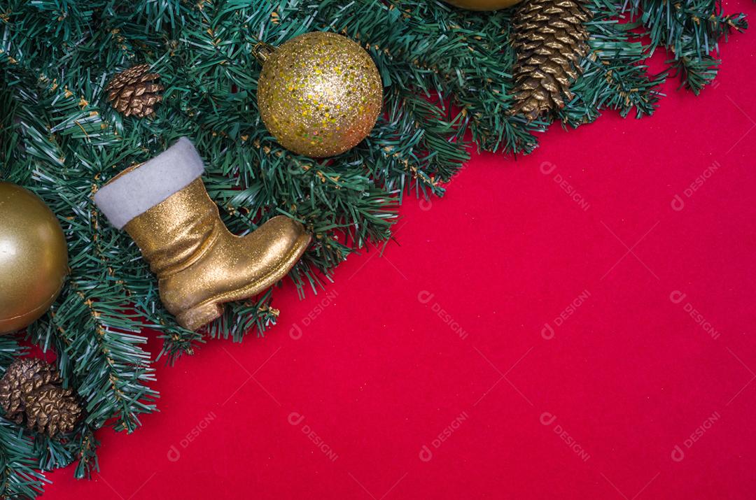 Textura com tema de Natal com folhas verdes, objetos decorativos e fundo vermelho.