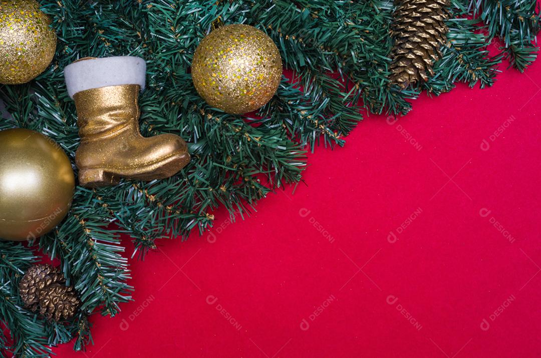 Textura com tema de Natal com folhas verdes, objetos decorativos e fundo vermelho.