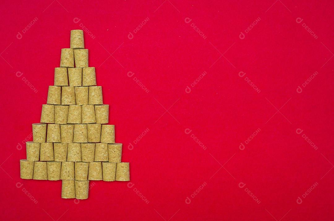 Fundo com tema de natal, árvore de natal com rolhas de vinho em fundo vermelho.