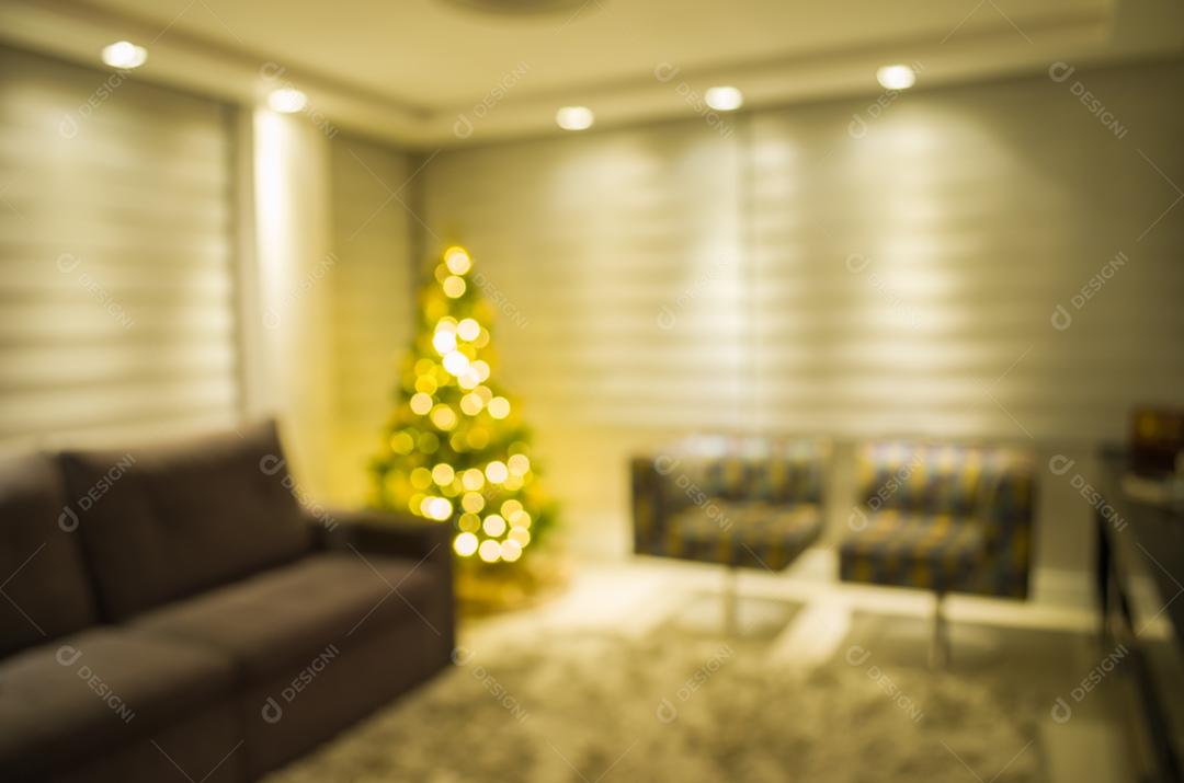 Grande fundo desfocado com tema de Natal, pinheiro de Natal decorado com luzes na sala de estar.