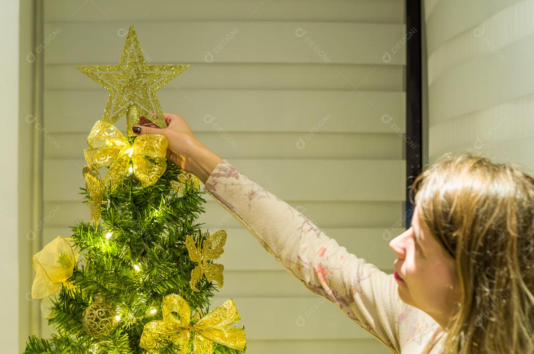 Grande conceito de mulher de Natal colocando estrela