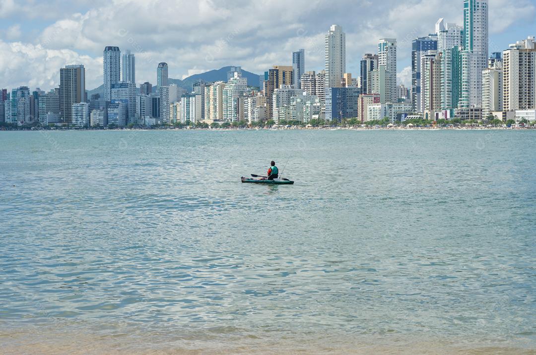 Jovem passeando de caiaque na praia brasileira. Caiaque de pesca.