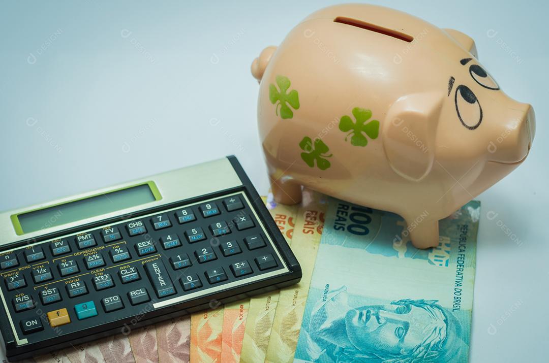 Ótimo conceito de economia, calculadora financeira, cofrinho e notas de dinheiro real brasileiro.