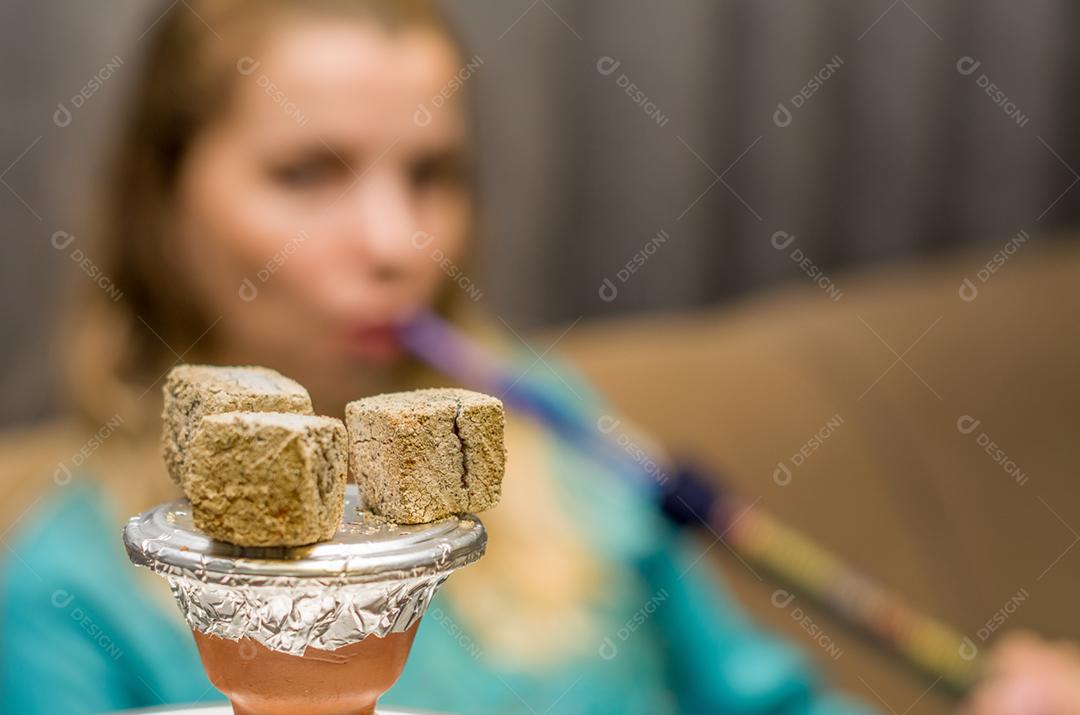 Mulher fumando cachimbo de água tradicional (Narguile, Shisha, Chicha, Arguile), equipamento