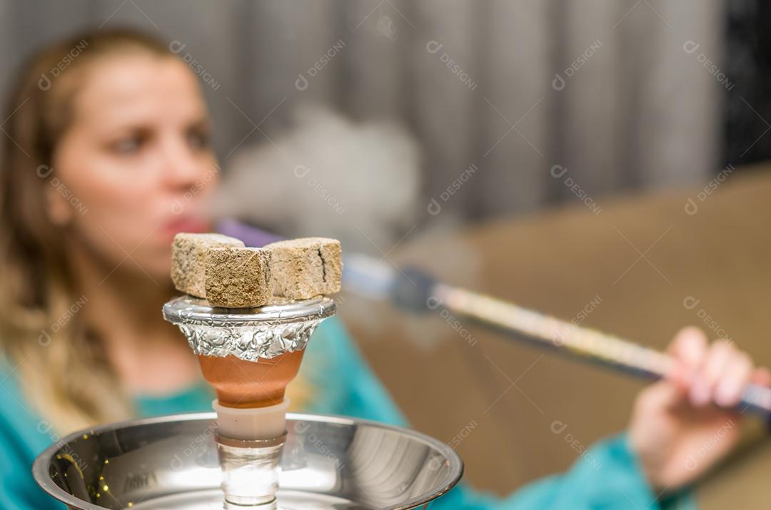 Mulher fumando cachimbo de água tradicional (Narguile, Shisha, Chicha, Arguile), equipamento