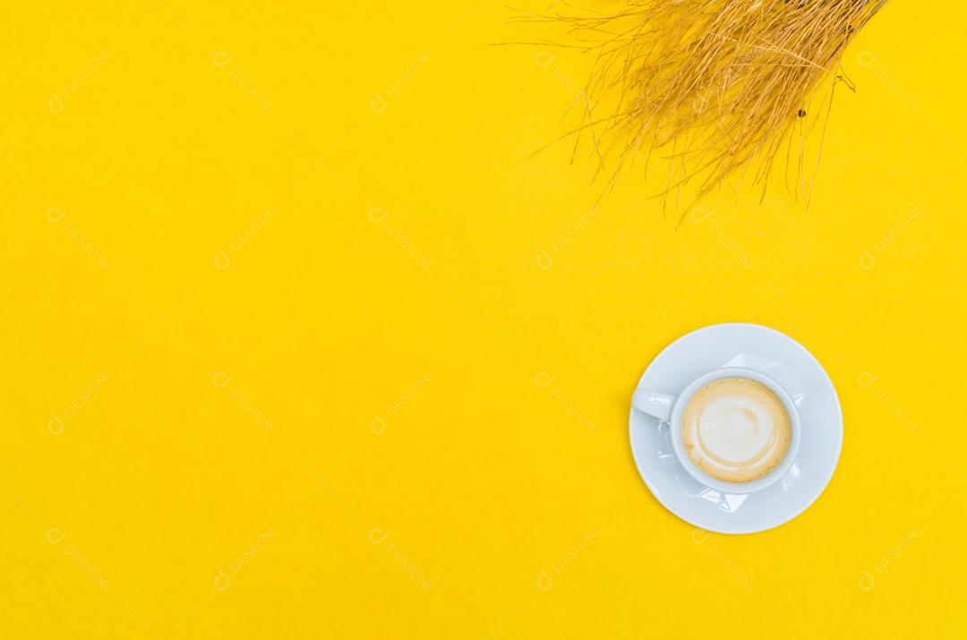 Xícara de café e palitos em fundo amarelo