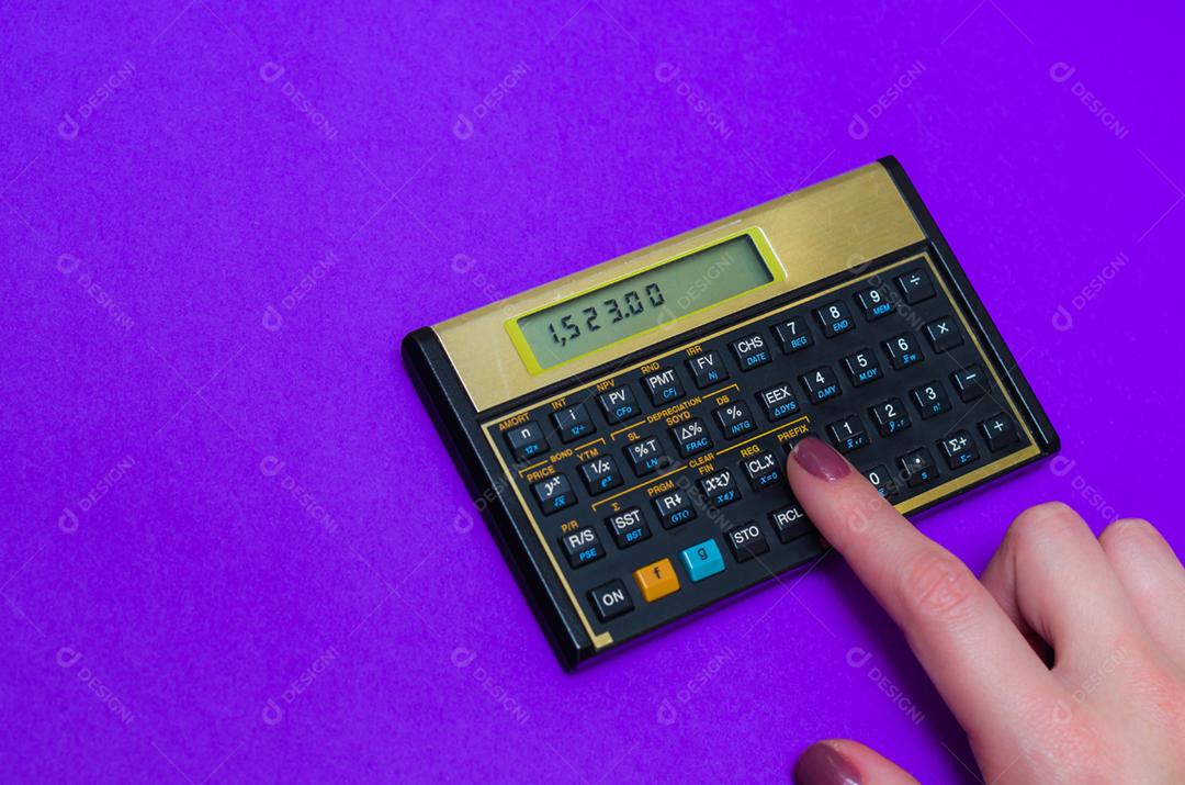 mão de mulher usando calculadora financeira em fundo azul vibrante, grande conceito de finanças