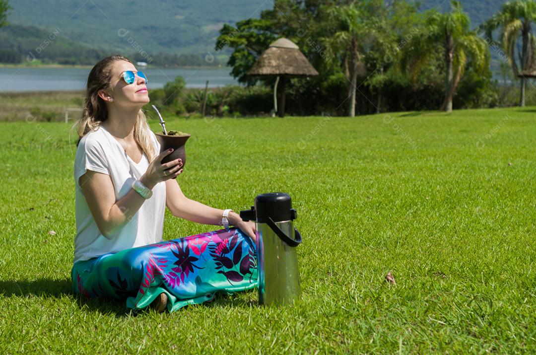 Mulher loira bebendo o tradicional Chimarrão do Estado do Rio Grande do Sul