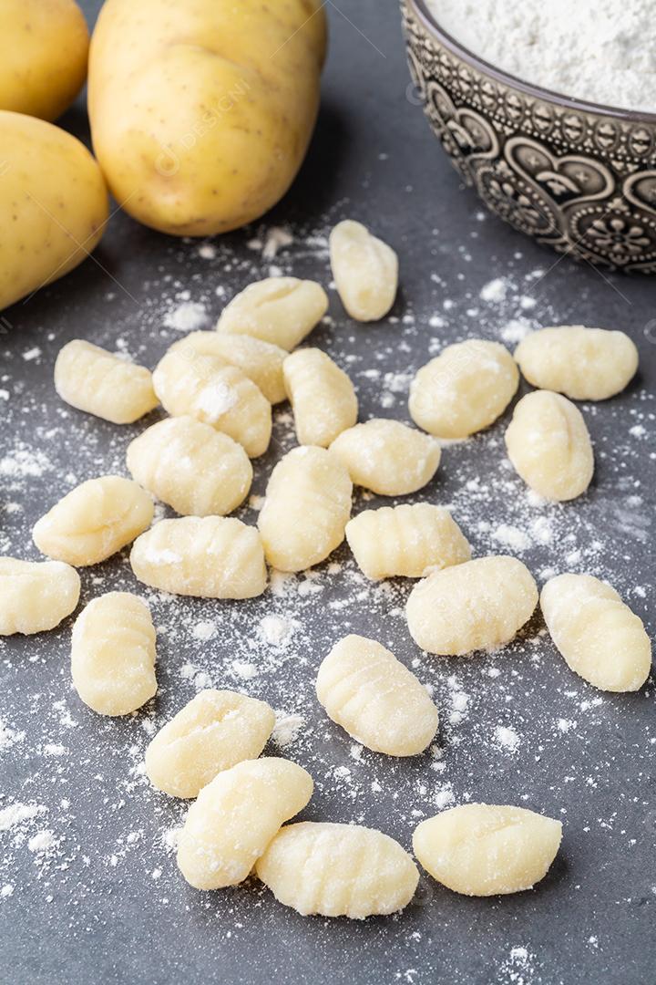 Nhoque de macarrão italiano cru sobre fundo de pedra.